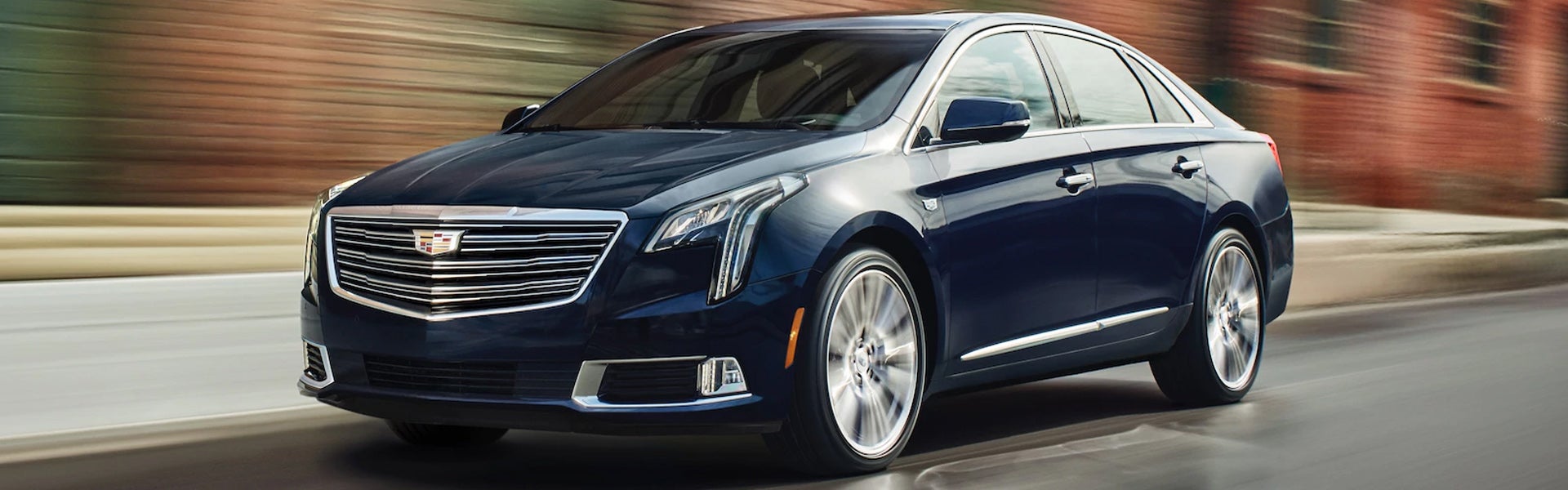 Front side view of a Cadillac XTS vehicle driving on the road